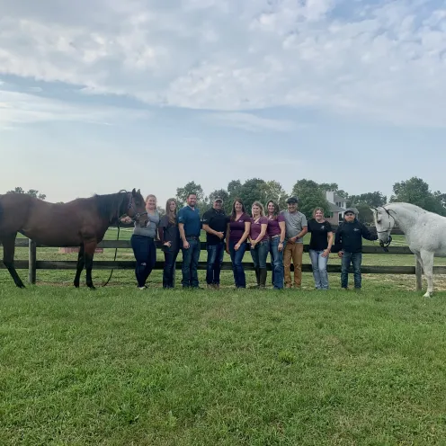 Abraham's Equine Clinic team and two horses standing on a field